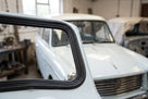 Windscreen seal lines the rear pillar of a pale classic estate car
