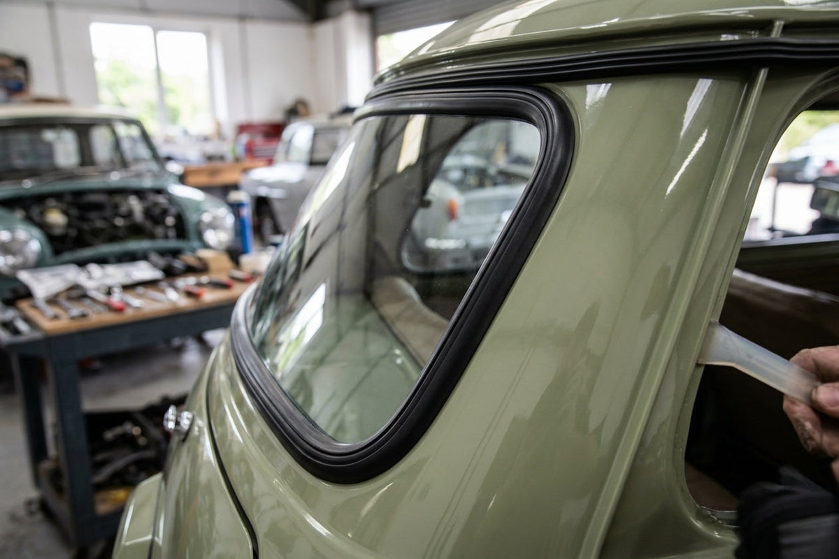 Black windscreen rubber seal fitted around the rear window of a green Mini Mk2