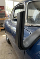 Black U-channel seal fitted along a window aperture edge on a blue classic car