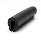 Black EPDM U-channel profile coiled, close-up end-on view of rounded keyhole-shaped groove