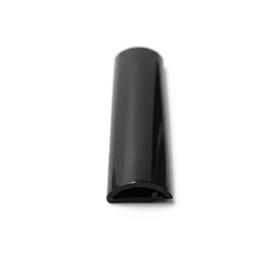 Glossy black PVC Herzim strip shown end-on, highlighting its curved trim profile
