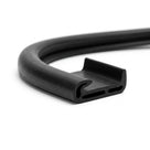 Coiled length of black rubber seal with a hooked channel profile, studio shot