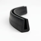 Black neoprene U-channel profile coiled, curved length showing tapered groove