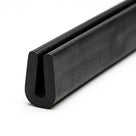 Black rubber U-channel profile coiled, angled view of narrow rounded groove