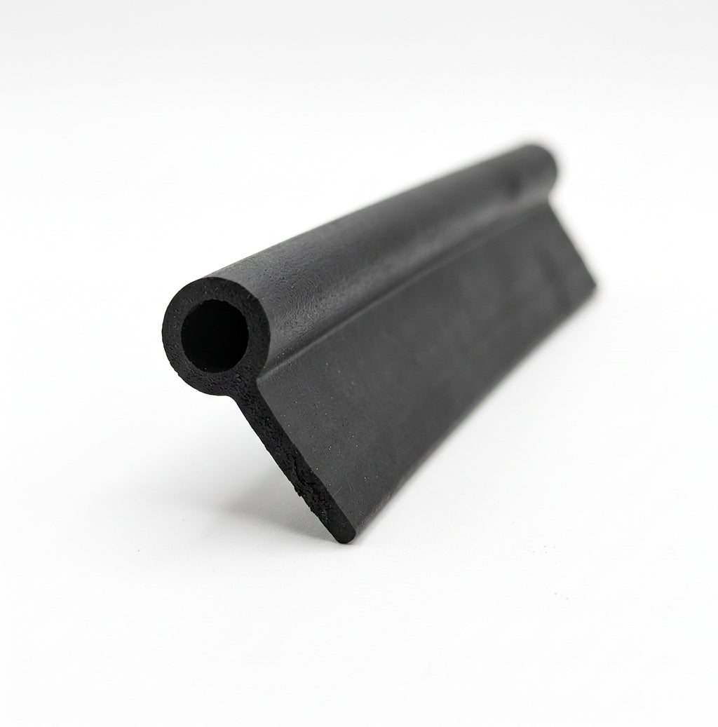 End-on view of black rubber tadpole section showing hollow bulb and flat tail