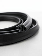 Black rubber spare wheel cover seal, coiled length with clover-shaped profile