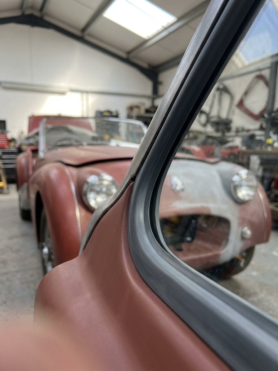 Windscreen to body seal fitted along the screen pillar of a red Triumph