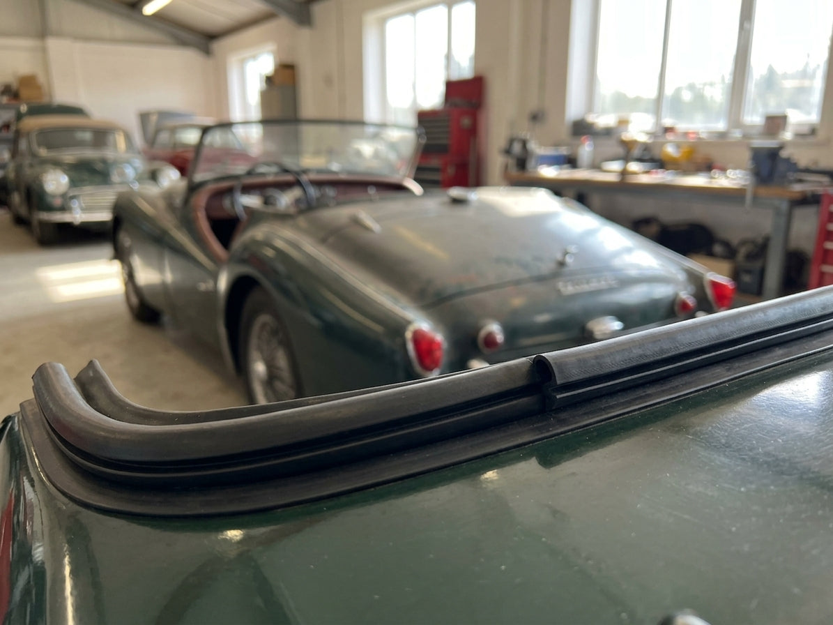 Hard top seal fitted along the roof edge of a green Triumph, garage setting