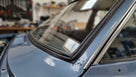 Black windscreen seal fitted to a light blue Cortina's screen corner with chrome trim