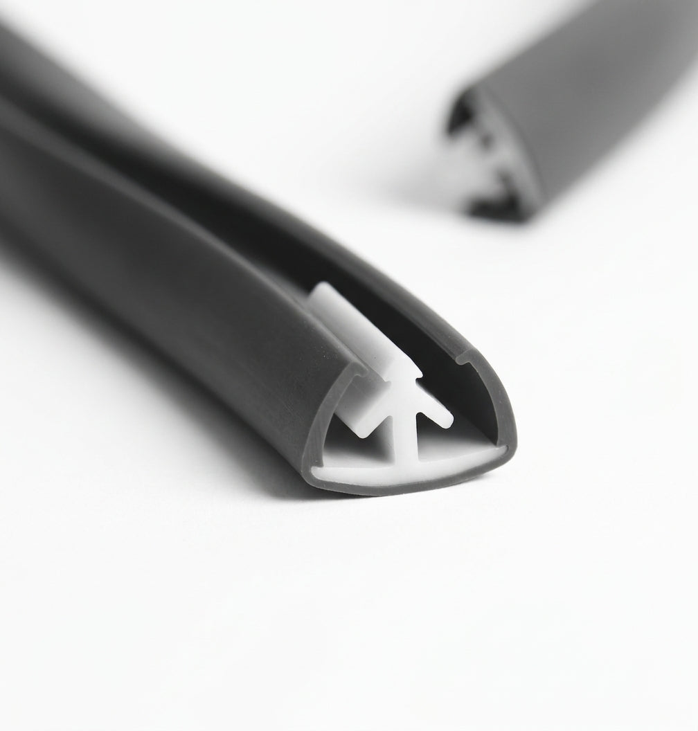 Dark grey edge trim shown end-on with a white plastic fixing clip inside the channel
