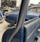 Chrome edge trim fitted along a window frame on a dark blue classic car
