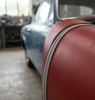 Chrome edge trim fitted to the wheel arch edge of a maroon classic car