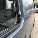 Tailgate seal fitted to the barn door edge of a blue-grey VW T4 van
