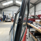 Self-grip seal fitted to a car door frame edge in a workshop