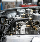 Black carb breather hose fitted near the carburettors in an engine bay
