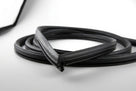Black windscreen surround coiled into a loose loop, white background