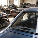 Black window seal fitted along a dark blue classic Cortina's side glass, workshop