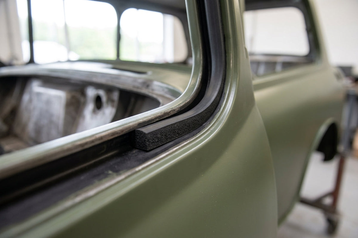 Sponge strip fitted along an olive green classic car's door frame