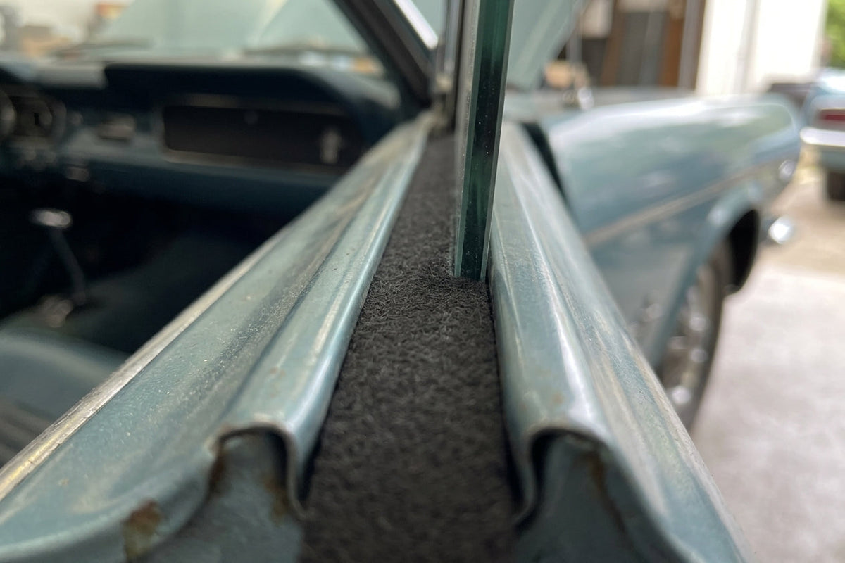 Black felt strip fitted into a classic car's door channel between glass and bodywork