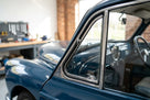 Quarterlight seal fitted around the chrome frame of a blue classic car's front window