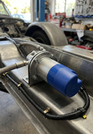 Fuel pump with blue cap mounted on a vehicle chassis rail, wiring harness attached