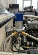 Electronic fuel pump with blue top installed on wing of a classic car in a workshop