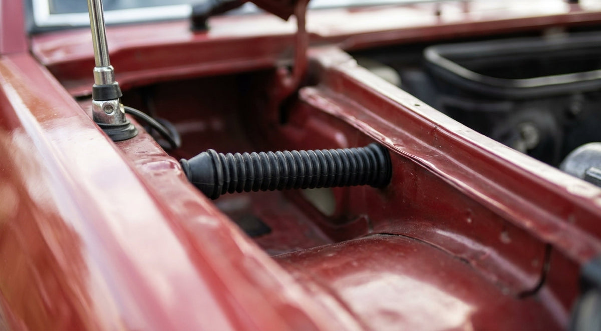 Black ribbed aerial grommet fitted through a red car's scuttle panel