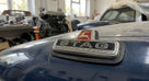 Chrome STAG badge with red deer emblem fitted to the boot lid of a blue Triumph Stag