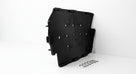 Black perforated plastic seat diaphragm panel with a coil spring, studio shot