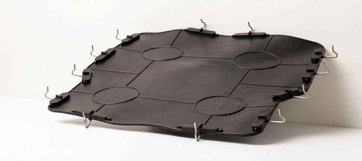 Black seat diaphragm panel with oval cutouts and wire hooks, studio shot