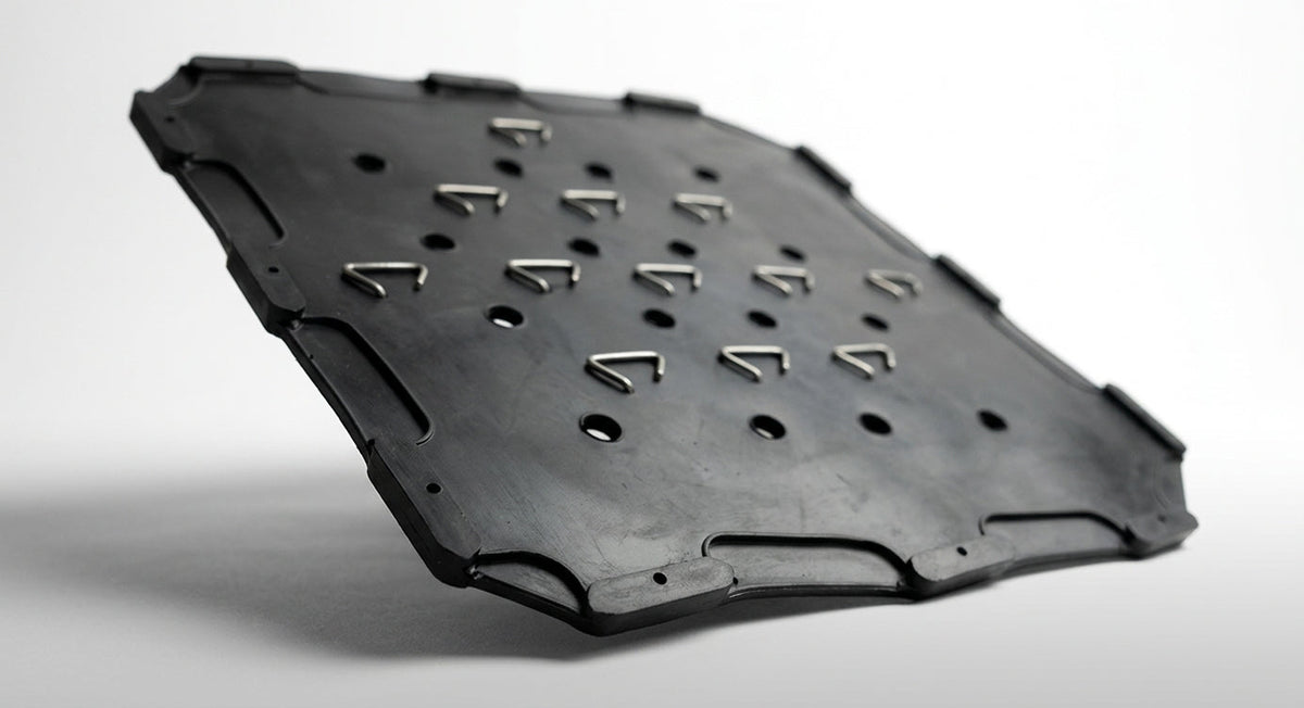 Black perforated seat diaphragm panel with triangular hooks, studio shot