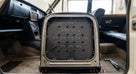 Perforated black seat diaphragm fitted within a seat frame in a car interior
