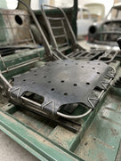 Perforated black seat diaphragm panel fitted into a Mini seat frame during restoration