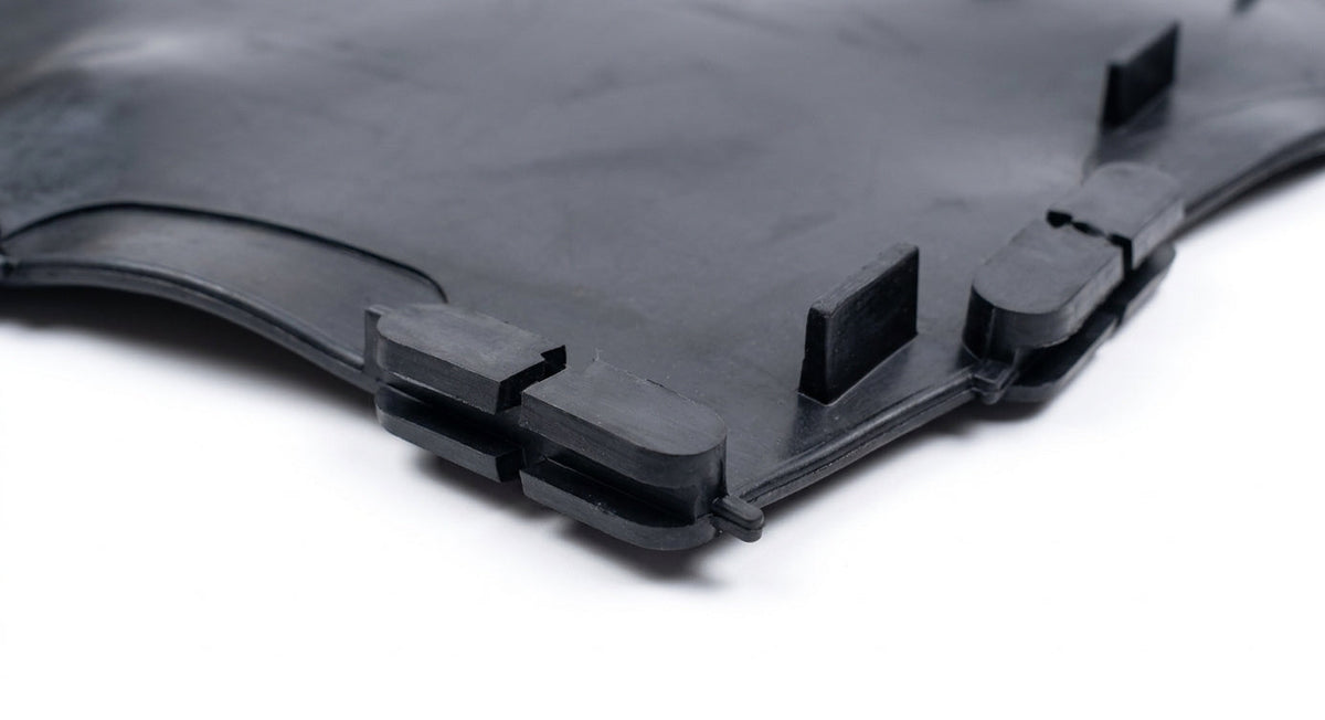 Close-up corner of a moulded black rubber seat diaphragm, white background