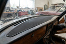 Black textured rubber dashboard pad fitted along the top of a wood-trimmed dashboard