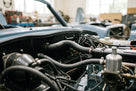Ribbed black heater hoses fitted in the engine bay of a blue classic car