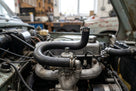 Inlet manifold water hose fitted in situ on a classic car's cylinder head