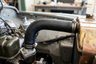 Black radiator hose fitted between engine and radiator, secured with clips