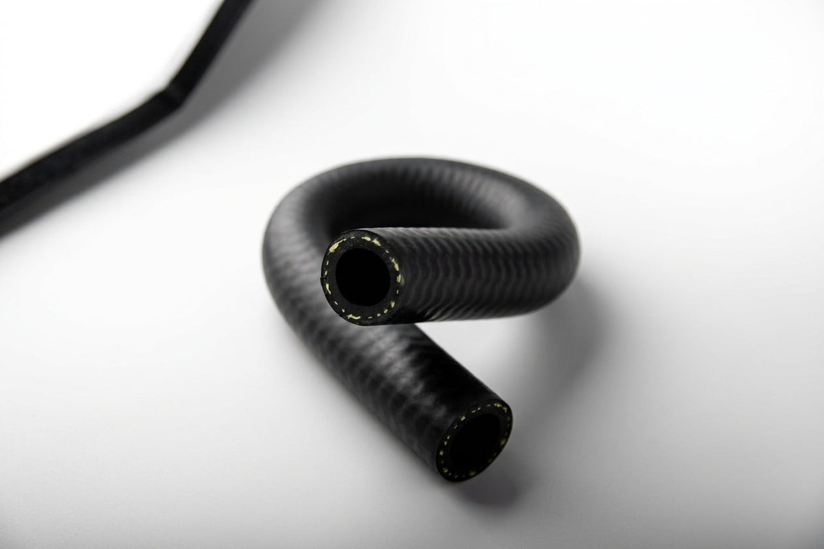 Black woven rubber heater hose coiled into a loop, close-up studio shot