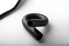 Black woven rubber heater hose coiled into a loop, close-up studio shot
