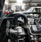 Black water pump hose fitted looping over the pump housing in an engine bay