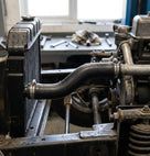 Radiator bottom hose fitted in situ between radiator and engine in a workshop