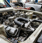 Black hose looping between the water pump cover and inlet manifold on a cream Stag