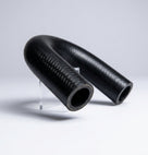 Black woven-finish bypass hose bent into shape, propped on a clear stand