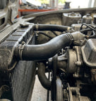 Black hose connecting the radiator to the engine, fitted with jubilee clips