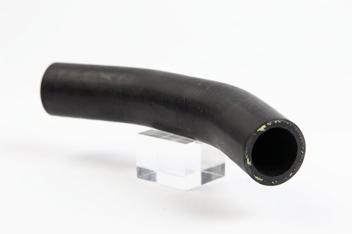 Curved black rubber radiator hose on a clear stand, studio white background