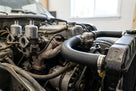 Black rubber bottom radiator hose fitted in situ in a Spitfire engine bay