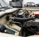 Black Y-shaped hose fitted to the water valve in a classic car engine bay