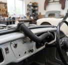 Corrugated demister hose routed across a Triumph's dashboard, steering wheel visible