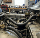 Black hose fitted between water valve and heater in a classic car engine bay
